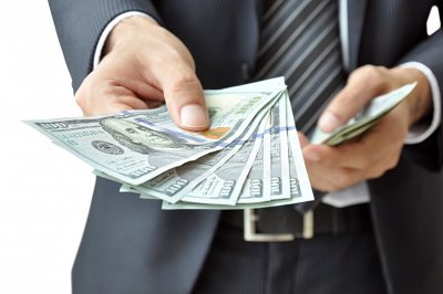 Mężczyzna wręczający plik banknotów